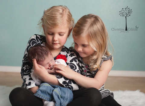 big sisters adoring new baby brother