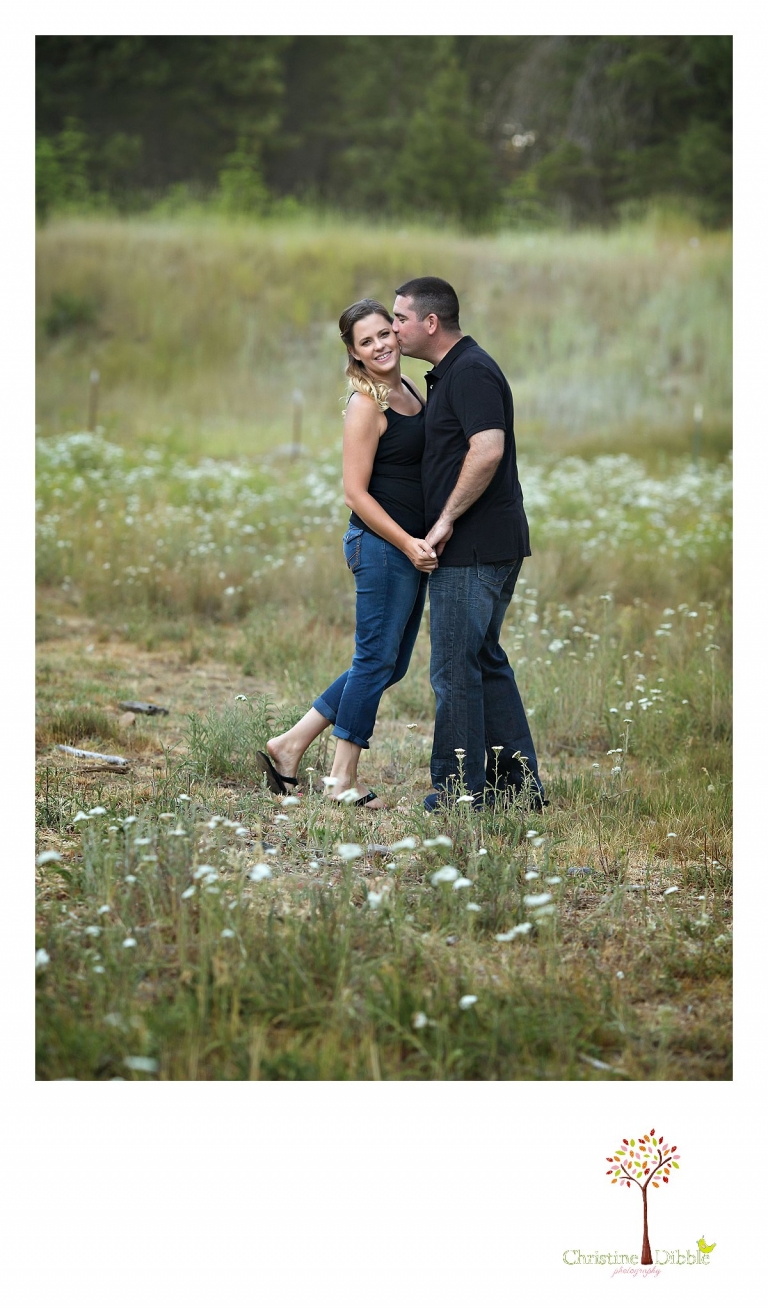 An engeged couple sit among a field of wildflowers while Sonora, CA engagement and wedding photographer Christine Dibble Photography takes their photos.