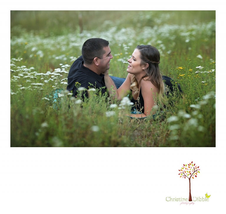 An engeged couple sit among a field of wildflowers while Sonora, CA engagement and wedding photographer Christine Dibble Photography takes their photos.