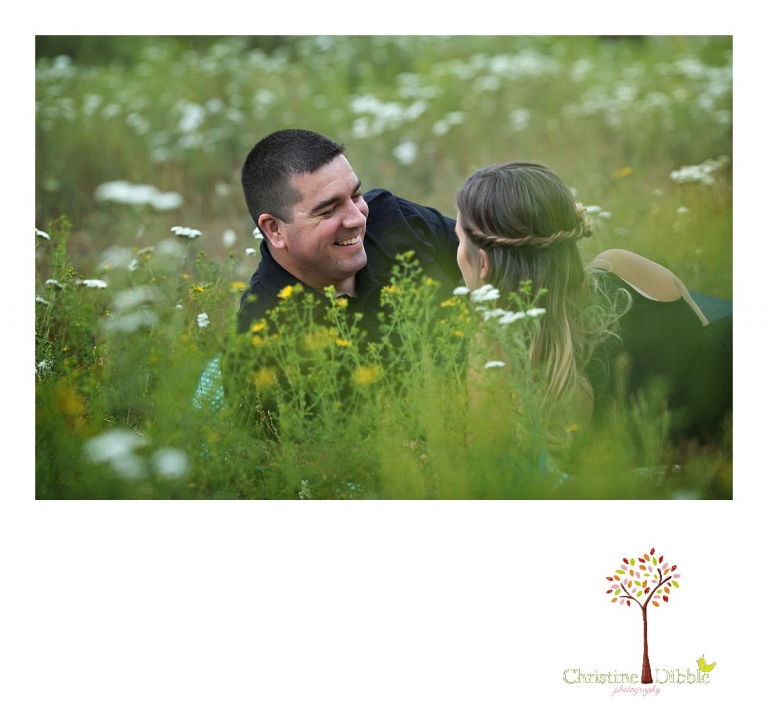 An engeged couple sit on a quilt and talk among a field of wildflowers while Sonora, CA engagement and wedding photographer Christine Dibble Photography takes their photos.