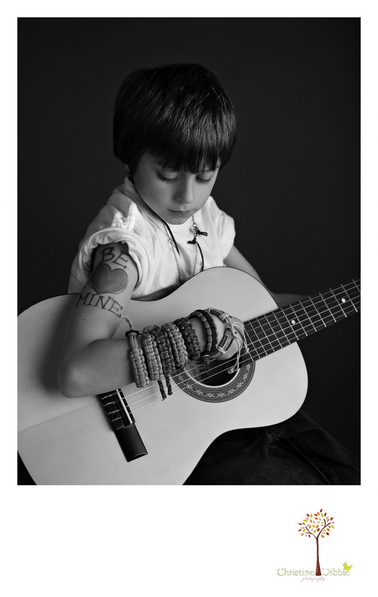Sonora childrens photographer Christine Dibble Photography takes black and white studio photos of a boy with a guitar and a mom tattoo.