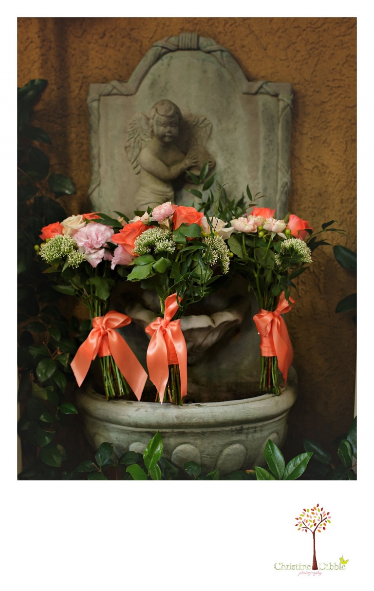 Sonora wedding photographer Christine Dibble Photography  photographs the the bridesmaids' bouquets with bright orange and red flowers before a sunset beach wedding at Moran Lake Beach in Santa Cruz.