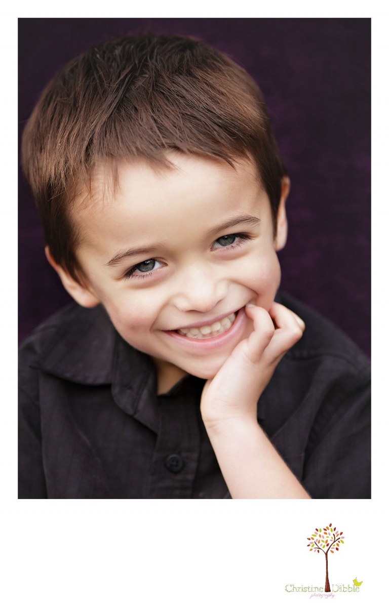 Sonora childrens photographer Christine Dibble Photography takes photos of a little boy as he smiles for a head shot during a family multi-generation shoot.