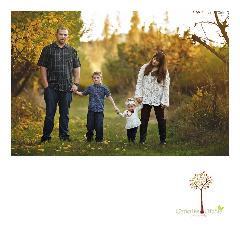 A family lines up to pose for a photo during a Sonora family photography session photographed by Christine Dibble Photography at Indigeny Reserve in the fall among the apple orchards.