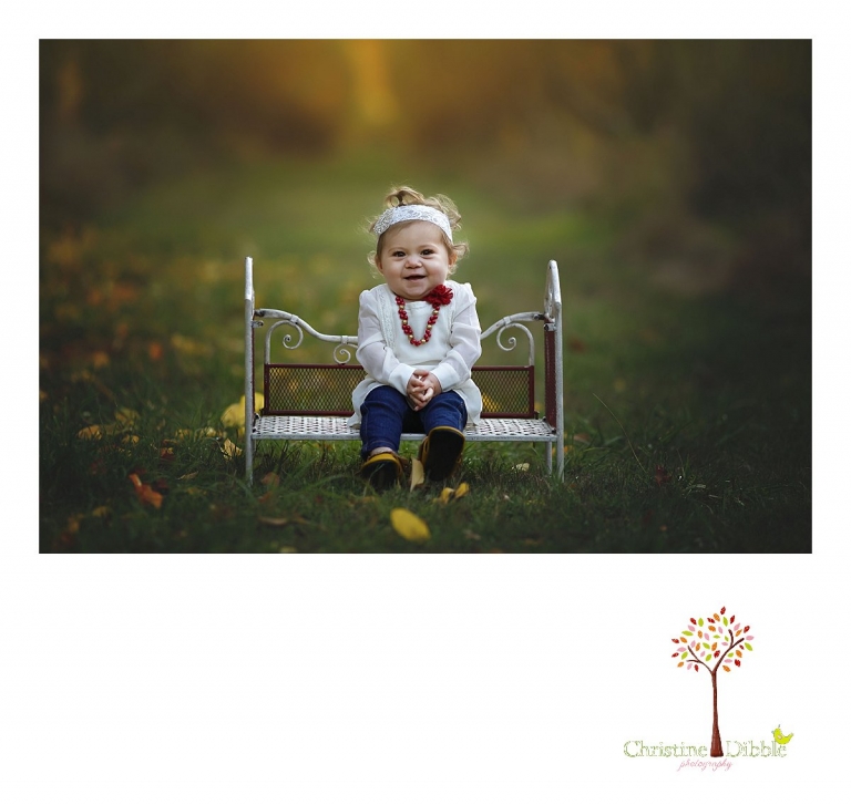 A baby girl sits on a miniature garden bed  during a Sonora family photography session photographed by Christine Dibble Photography at Indigeny Reserve in the fall among the apple orchards.