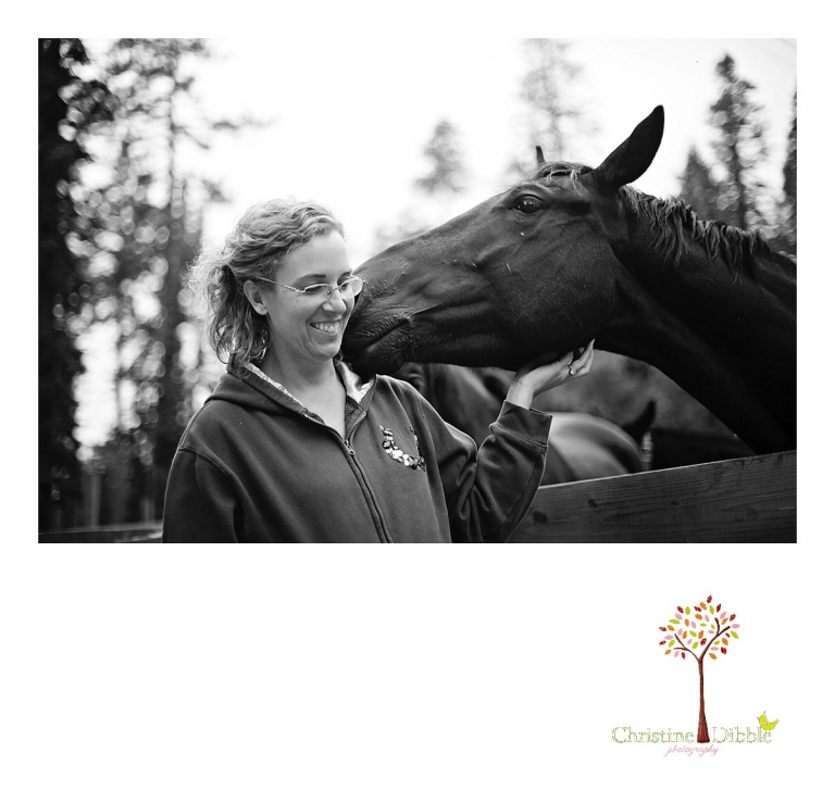 A black horse nibbles his owner's ear at Aspen Meadows Pack Station while Christine Dibble Photography photographs a lifestyle session.