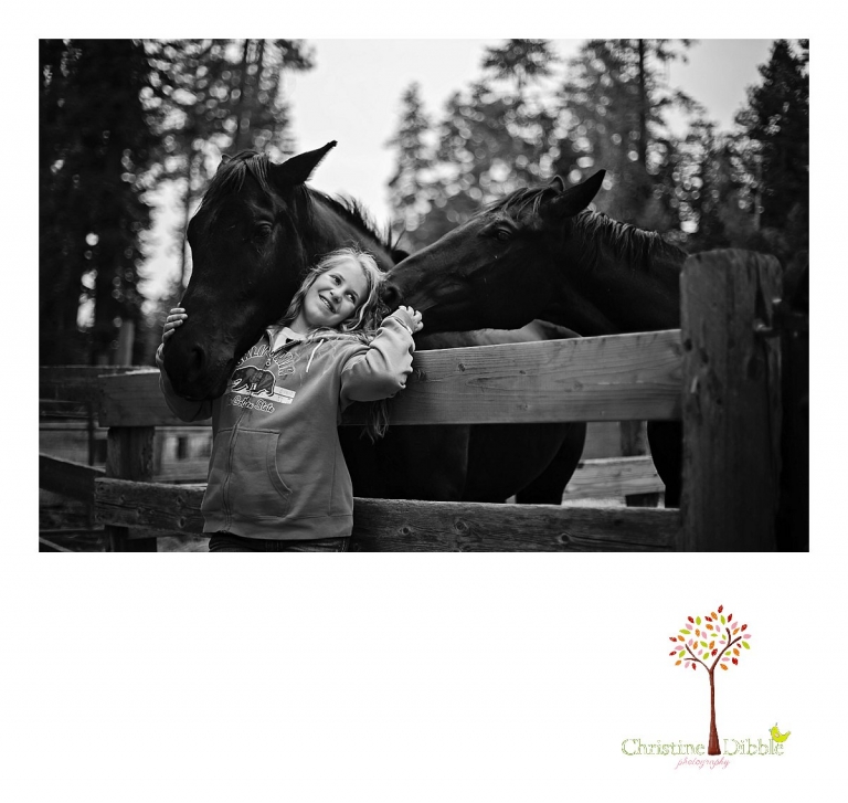 A young girl hugs her black horses while Christine Dibble Photography photographs a lifestyle session at Aspen Meadows.