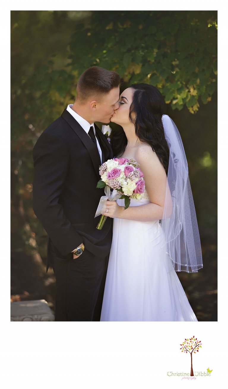 Christine Dibble Photography, Sonora and Reno wedding photographer, photographs a bride and groom as they kiss behind Rancho San Rafael Park in Reno after their wedding ceremony.