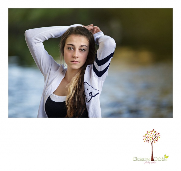 Sonora and Summerville senior portrait photographer Christine Dibble Photography takes outdoor photos of a senior girl with brown eyes during golden hour on the banks of the river at Knights Ferry.