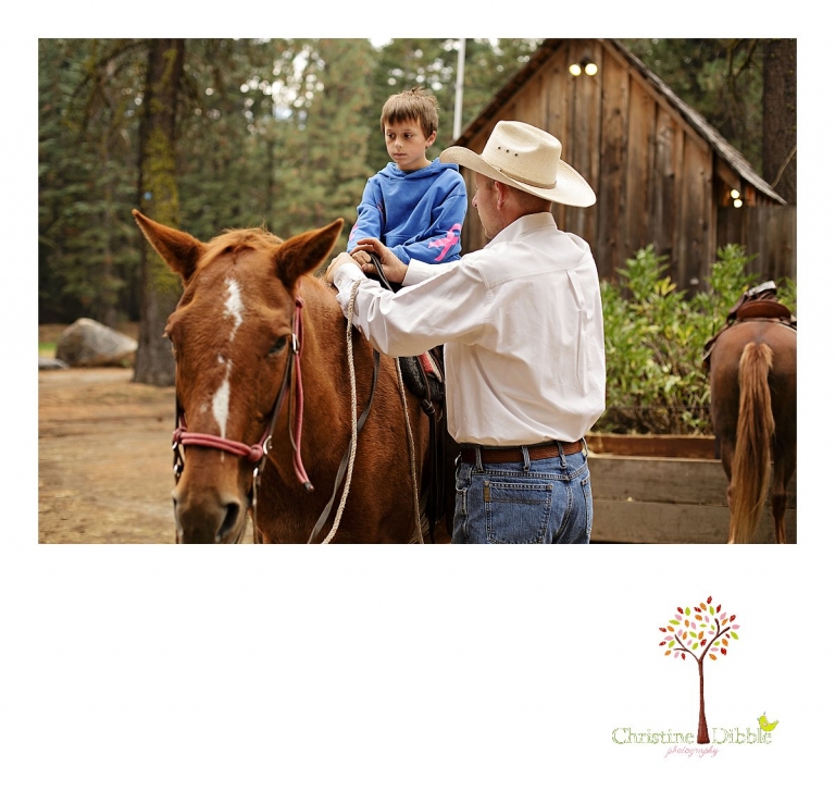 A cowboy helps a boy get settled on his horse for a trail ride at Aspen Meadows photographed by Sonora photographer Christine Dibble Photography.
