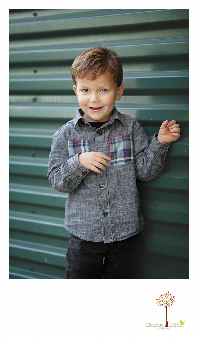 Sonora photography by Christine Dibble Photography captures photos of a little boy in front of a blue green wall during mini sessions at Sierra College in Grass Valley.