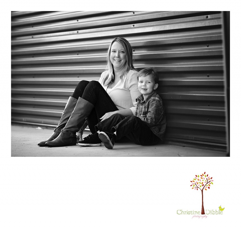 Sonora photography by Christine Dibble Photography captures photos of a little boy sitting with his mom in front of a blue green wall during mini sessions at Sierra College in Grass Valley.