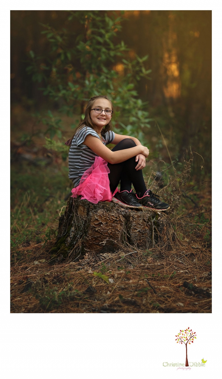 Sonora photography by Christine Dibble Photography captures photos of a tween girl sitting on a stump in the woods at Empire Mine State Park in Grass Valley during mini sessions.