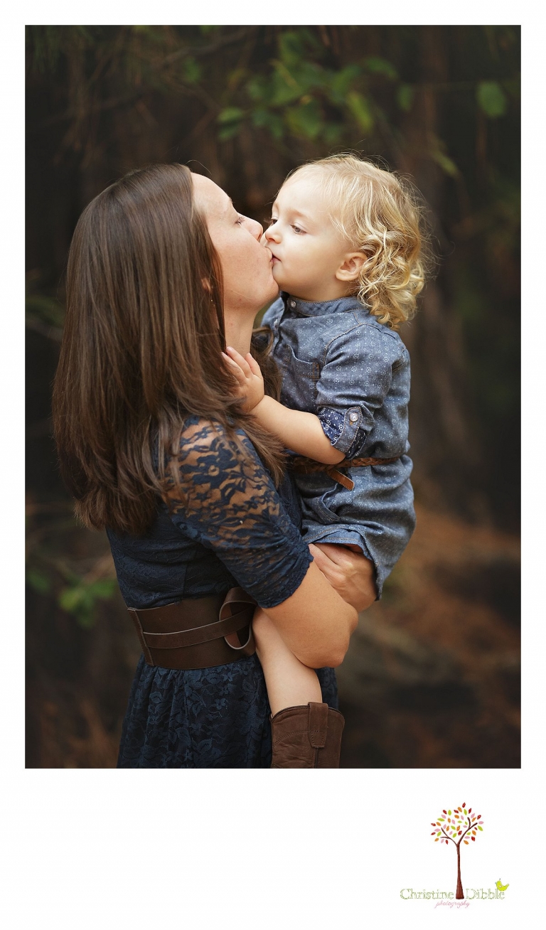 Sonora photography by Christine Dibble Photography captures photos of a mom kissing her little girl during mini sessions at Empire Mine State Park in Grass Valley.