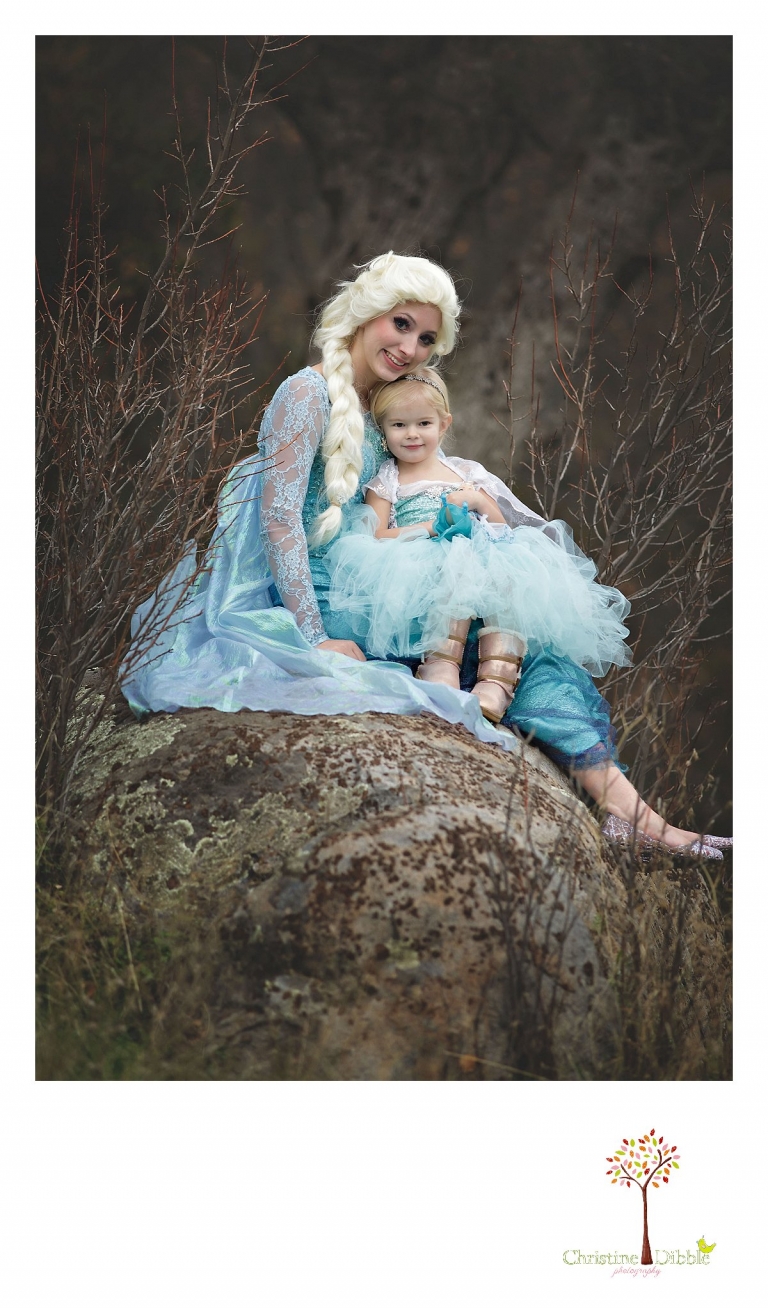 Sonora Elsa photographer Christine Dibble Photography photographs the beautiful princess Elsa as she cuddles with a little girl near some bare winter branches.