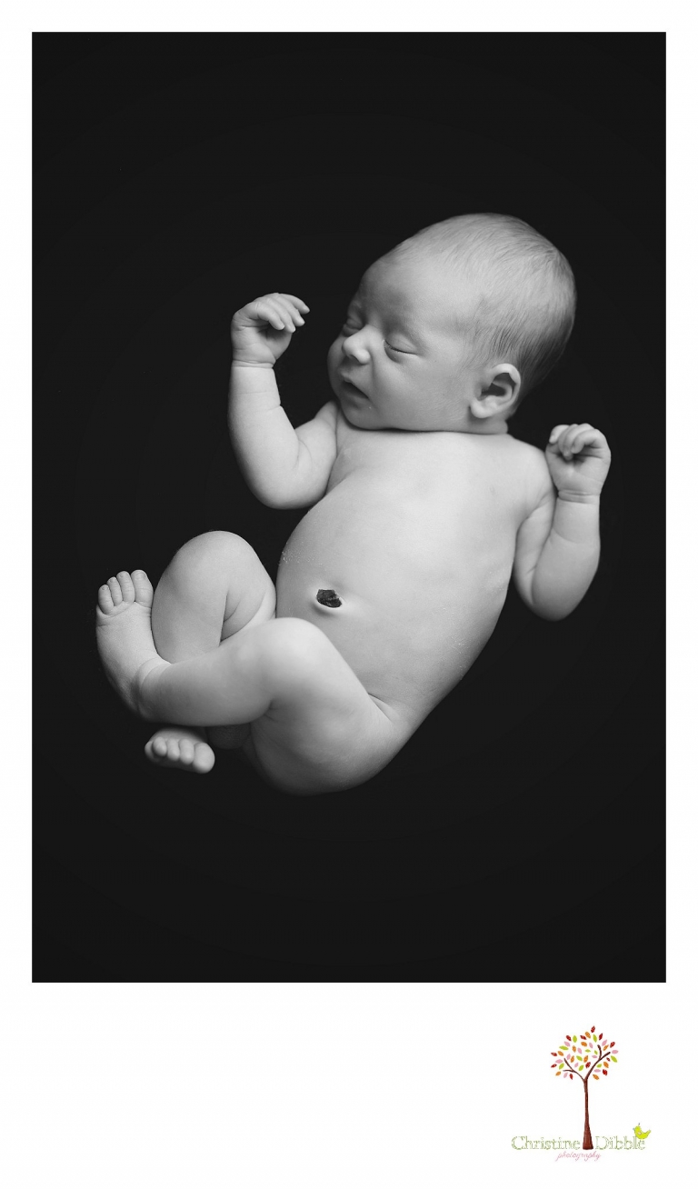 Best Sonora newborn photography by Christine Dibble Photography includes newborn portraits of a baby boy in black and white on a black background to look womb-like.