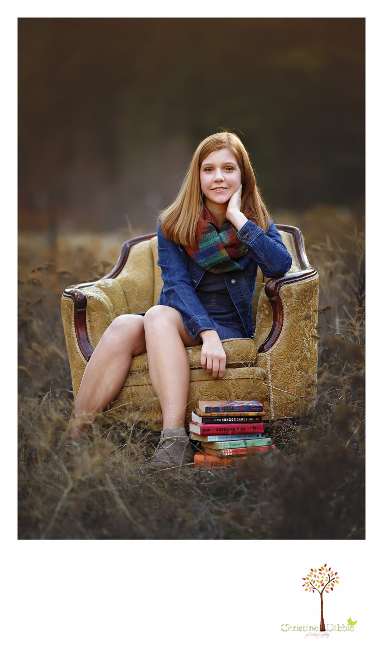 Sonora and Turlock senior portrait photographer Christine Dibble Photography takes outdoor fall senior photos of a girl in an antique chair in a field while wearing a denim jacket.