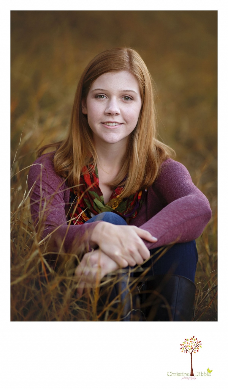 Sonora and Turlock senior portrait photographer Christine Dibble Photography takes outdoor fall senior photos of a girl wearing purple in a fall-colored field of grass.