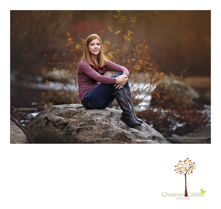 Sonora and Turlock senior portrait photographer Christine Dibble Photography takes outdoor fall senior photos of a girl sitting on a rock in the middle of a river.