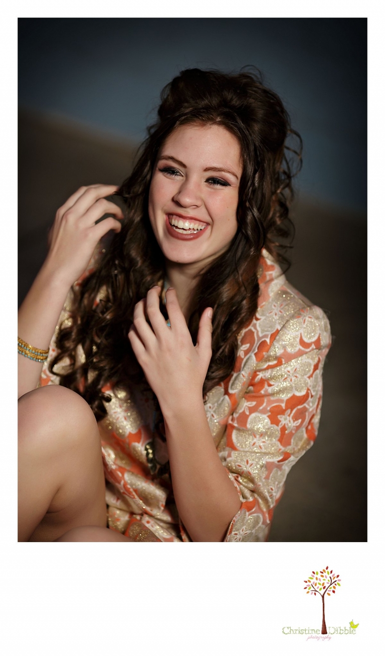 Sonora, CA senior model photographer Christine Dibble takes outdoor modeling photos of a teenage girl for a modeling portfolio while she wears a smile and laughs.