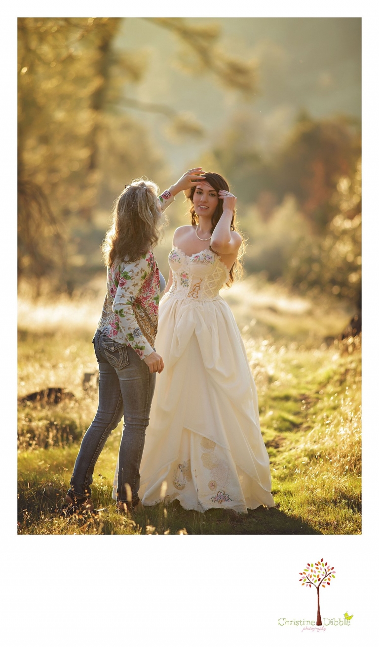 Sonora wedding photographer Christine Dibble Photography takes outdoor sunset photos Katherine fixing the hair of a model wearing a dress crafted of vintage linens and a hair flower by Hopefully Romantic near Twain Harte.