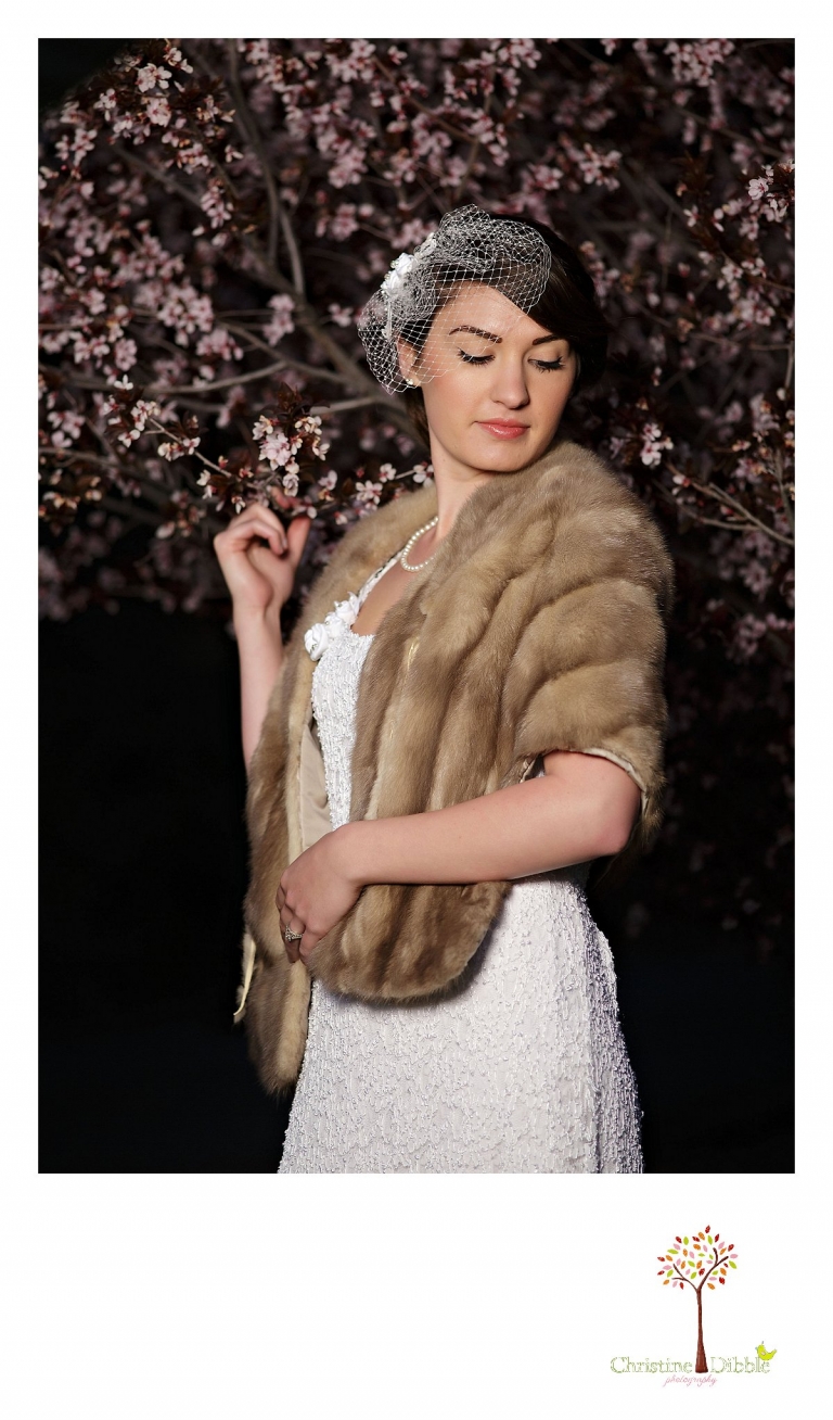 Sonora wedding photographer Christine Dibble Photography takes outdoor sunset photos of a model wearing a dress crafted of vintage linens and a bird cage veil among pink blossoms by Hopefully Romantic near Twain Harte.