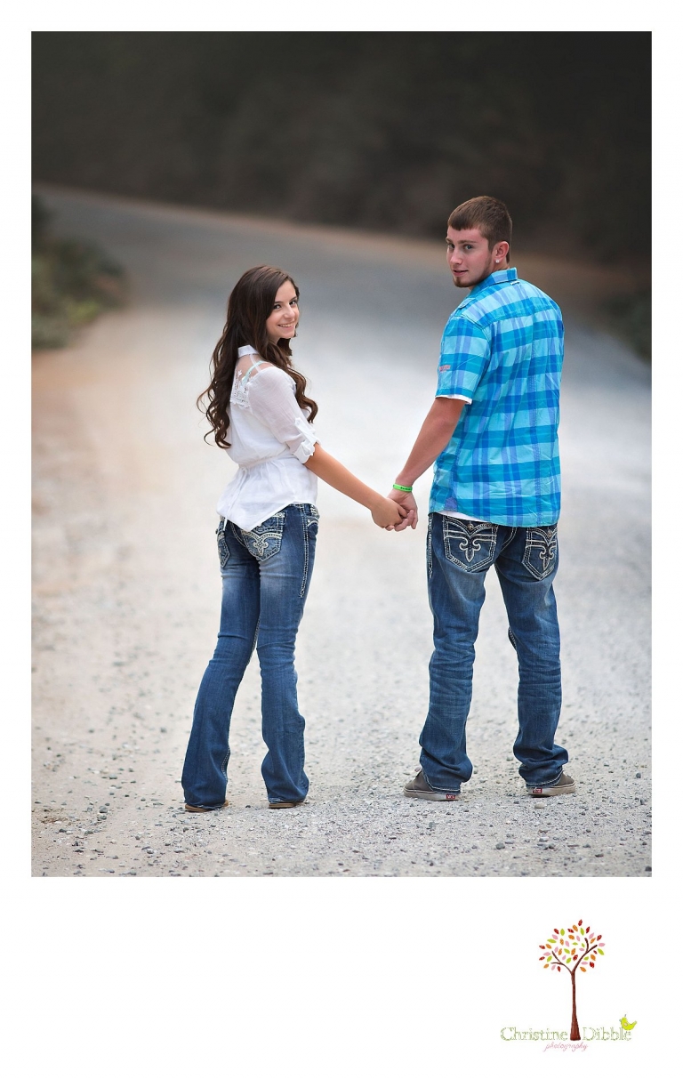 Sonora, Summerville and Turlock senior portrait photographer Christine Dibble Photography takes outdoor senior photos of a senior couple from Turlock looking back as they walk away during a joint senior portrait session outside Twain Harte.