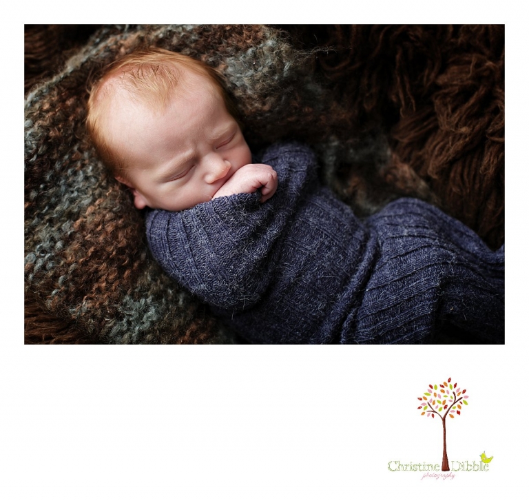 Best Sonora, CA newborn photographer Christine Dibble Photography takes studio photos of a baby boy as he sleeps in a newborn sock on a hand knit layering piece and a flokati rug during his newborn photography session.