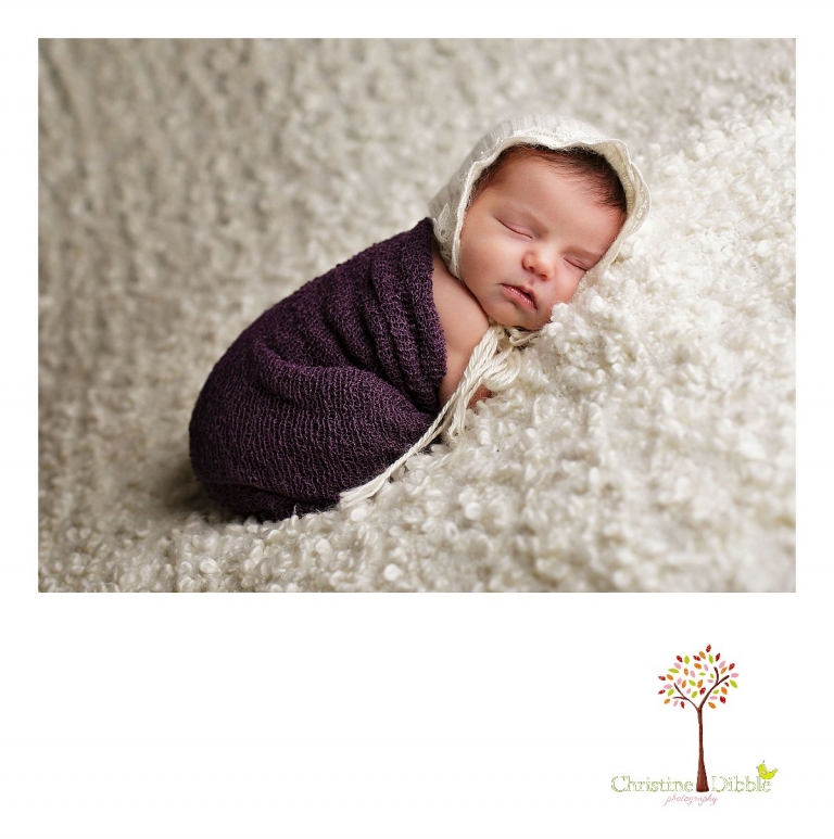 Sonora, CA newborn photography session by best Sonora newborn photographer Christine Dibble Photography features images of a baby girl in a purple wrap and a cream upcycled bonnet.