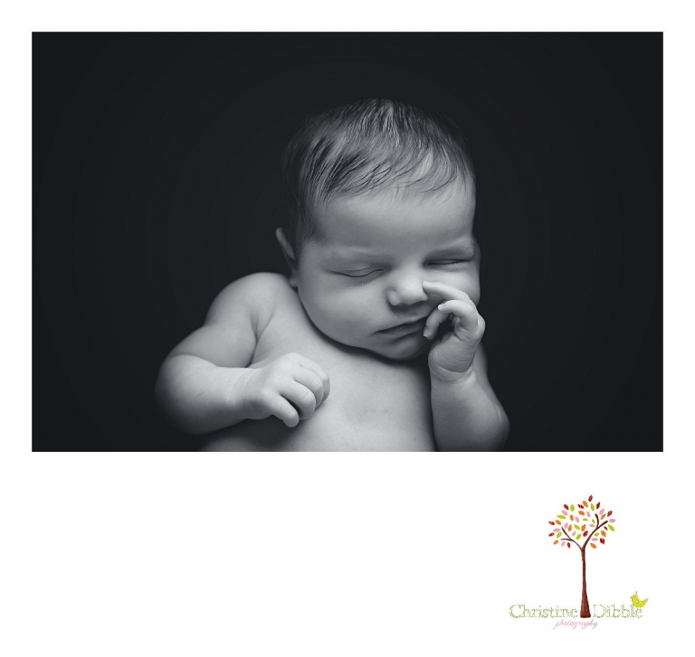 A black and white womb-style photo is taken during a Sonora, CA newborn photography session by best Sonora newborn photographer Christine Dibble Photography of a baby girl's face as she sleeps.