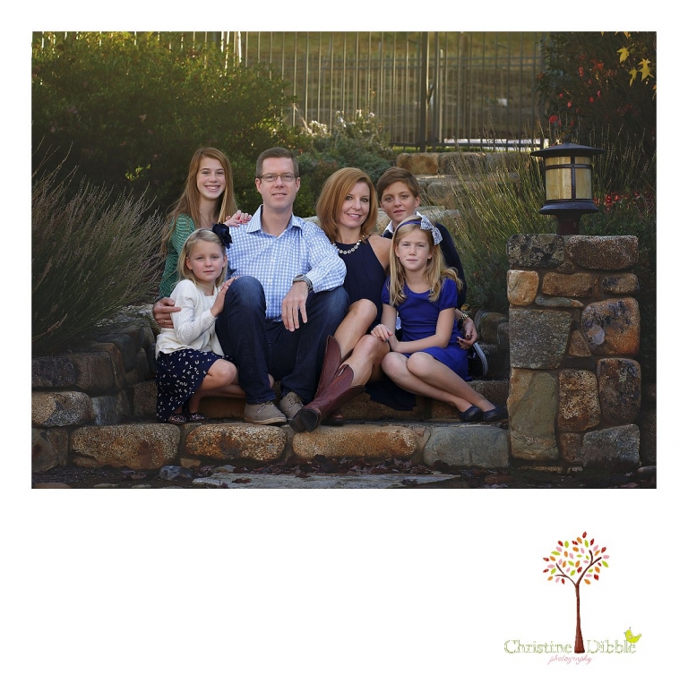 Christine Dibble Photography, best Sonora family photographer, takes outdoor portraits of a blended family sitting on stone steps in their renovated backyard in Tuolumne.