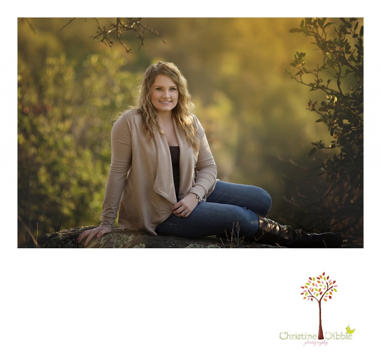 Sonora and Summerville High School senior portrait photographer Christine Dibble Photography takes outdoor photos of a beautiful senior girl sitting on a large granite boulder on the edge of a hillside.