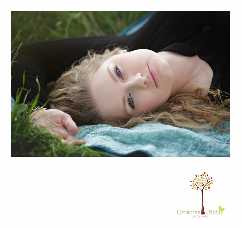 Sonora and Summerville High School senior portrait photographer Christine Dibble Photography takes outdoor photos of a beautiful senior girl lying on a quilt.
