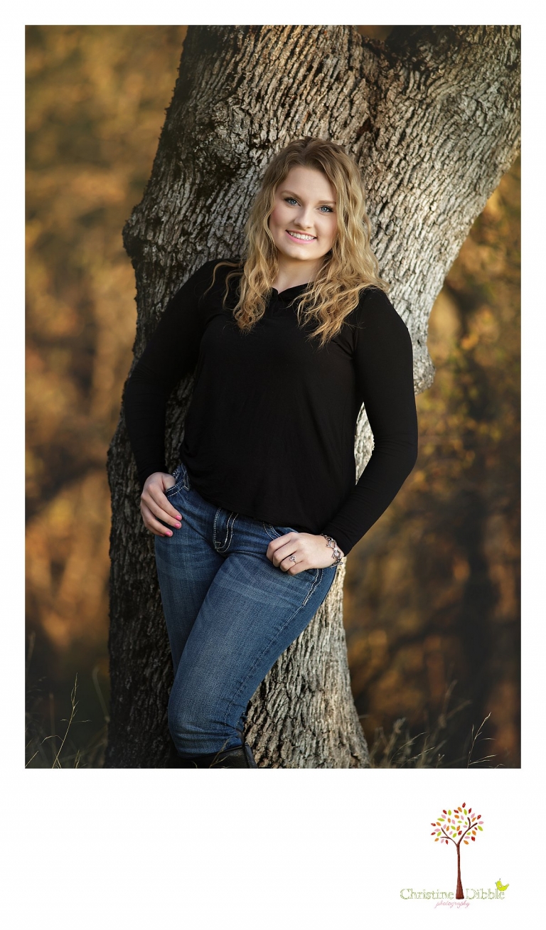 Sonora and Summerville High School senior portrait photographer Christine Dibble Photography takes outdoor photos of a beautiful senior girl leaning on an oak tree during golden hour.