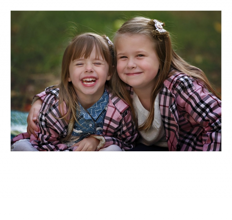 Two children in matching jackets pose for a sister portrait during a autumn Sonora, CA family photography session at Indigeny Reserve by Christine Dibble Photography.