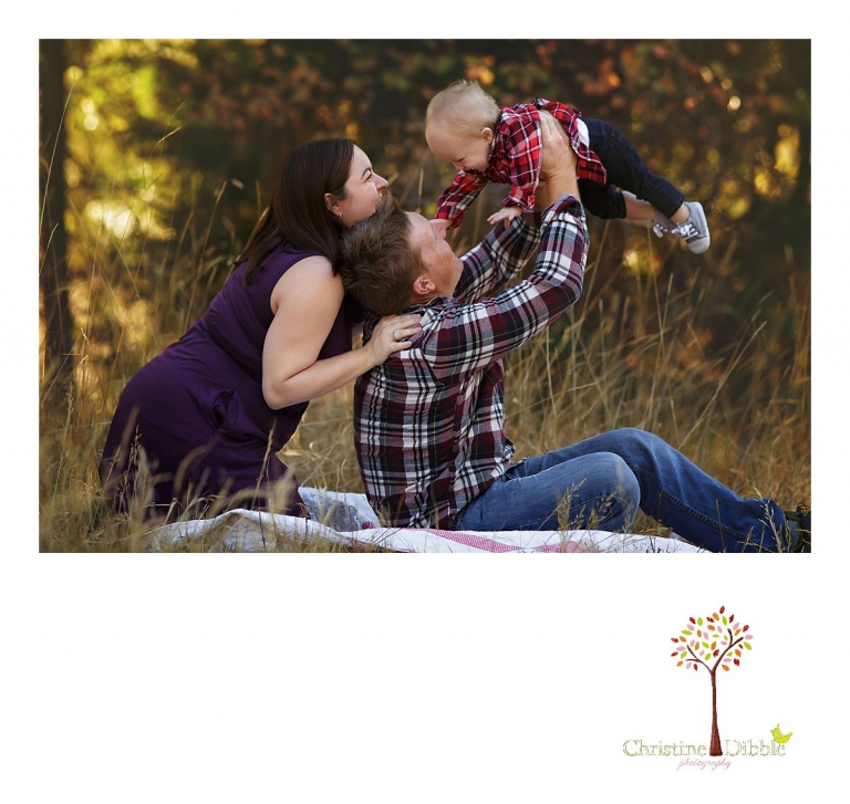 Sonora child photographer Christine Dibble Photography photographs a baby girl's first birthday session outdoors in a field as she plays with mom and dad.