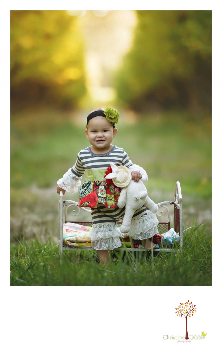 Sonora child and baby photographer Christine Dibble Photography takes first birthday portraits of a baby girl in the apple orchards at Indigeny Reserve during the fall and using a small iron bed.