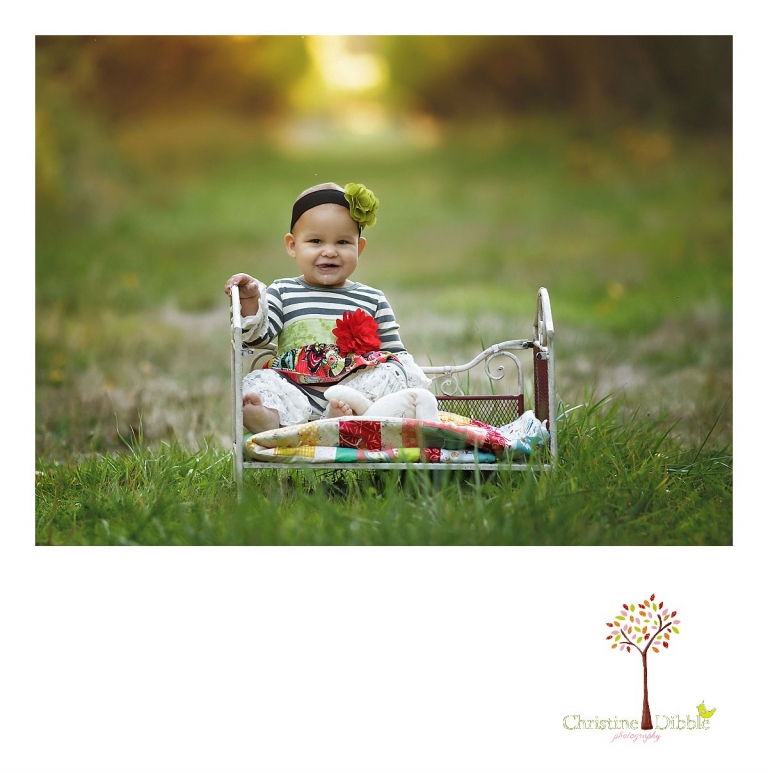 Sonora child and baby photographer Christine Dibble Photography takes first birthday portraits of a baby girl in the apple orchards at Indigeny Reserve using a small iron bed and a quilt made by the baby's older sister.