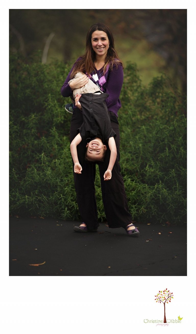 Sonora photographer Christine Dibble Photography takes a photo of mom hanging her young son upside down during  four generation family portraits outside on a foggy morning in the clients' yard.
