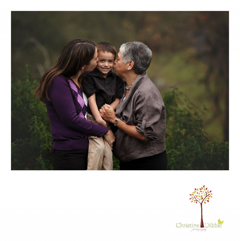 Sonora photographer Christine Dibble Photography takes a photo of mom and grandma kissing a boy on the cheeks during  four generation family portraits outside on a foggy morning in the clients' yard.