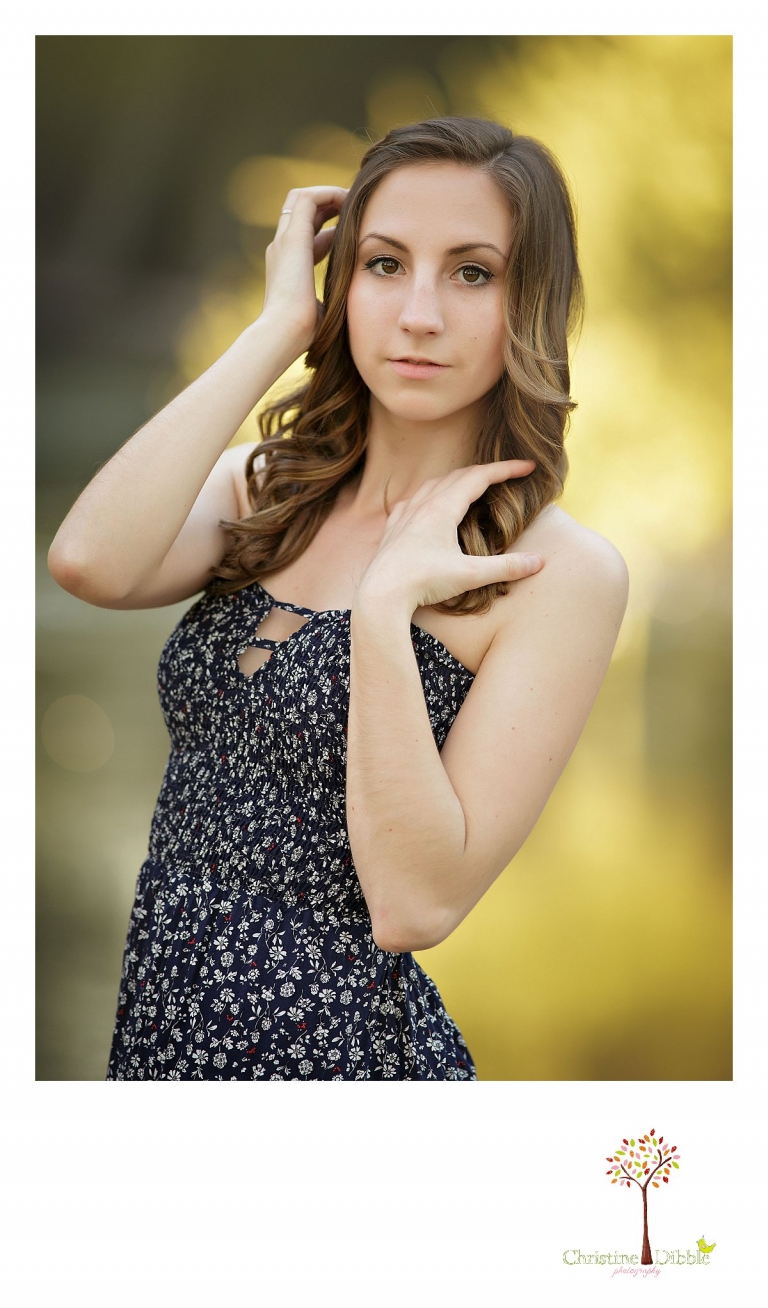 Bright yellow leaves glow behind a senior girl at Knights Ferry as Summerville and Sonora High senior portrait photographer Christine Dibble Photography takes portraits during a photography session by the river.