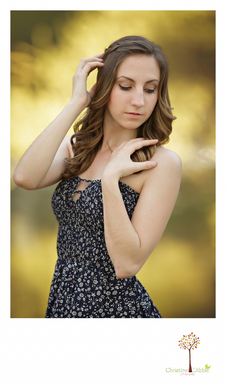 A senior girl shows off hair and make-up by Cassidy Wise during her senior portrait session at Knights Ferry photographed by Summerville and Sonora High senior portrait photographer Christine Dibble Photography.