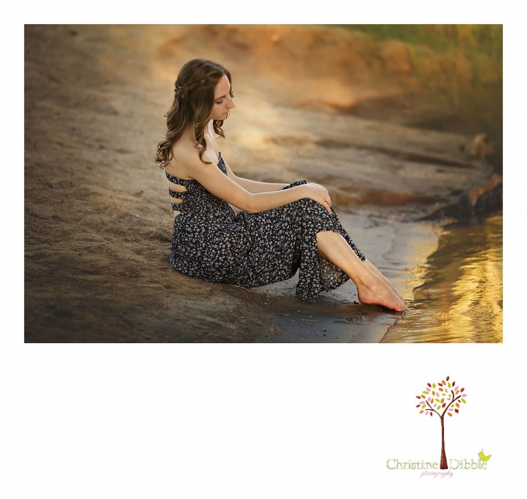 Summerville and Sonora High senior portrait photographer Christine Dibble Photography takes photos of a girl as she dips her bare toes into the cold river at Knights Ferry.