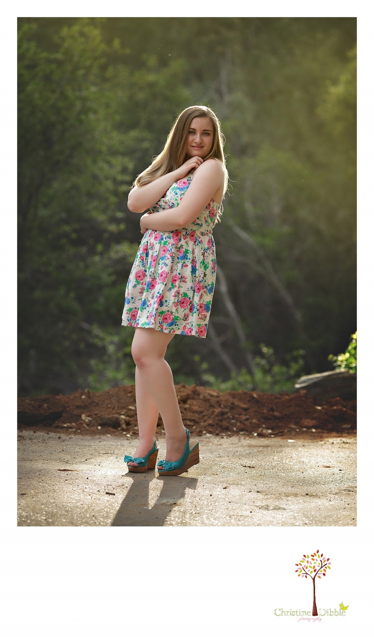 Sonora High senior portrait photographer Christine Dibble Photography takes portraits of a senior girl in a floral dress and wedge heels in an outdoor session.