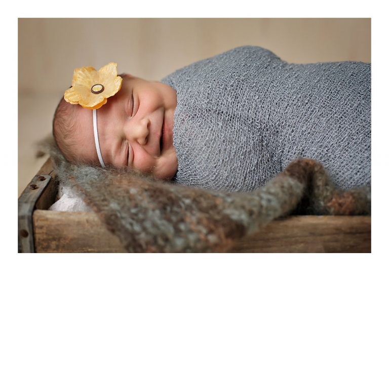 Sonora newborn photographer Christine Dibble Photography takes newborn portraits of babies smiling while wrapped in wraps and headbands on antique props.