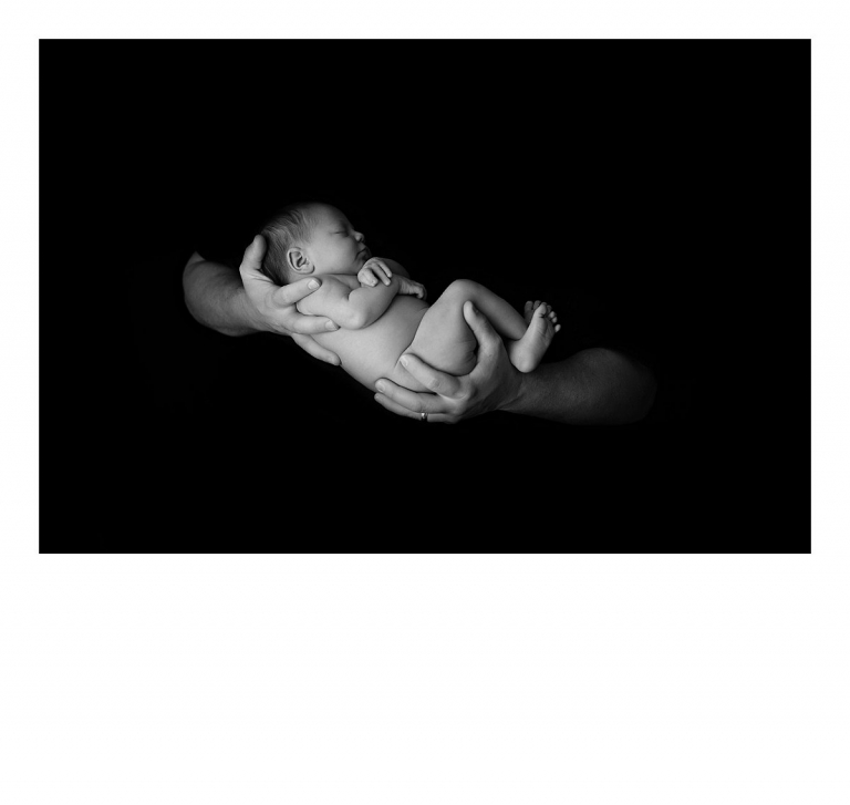 Sonora newborn photographer Christine Dibble Photography takes newborn portraits of babies sleeping in Dad's hands for a black and white photo.