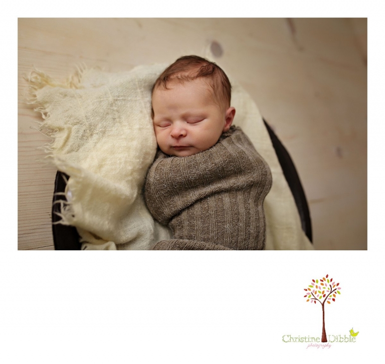 Best Sonora newborn photographer Christine Dibble Photography takes indoor studio photos of a newborn baby girl sleeping in a baby sock and wooden bowl.