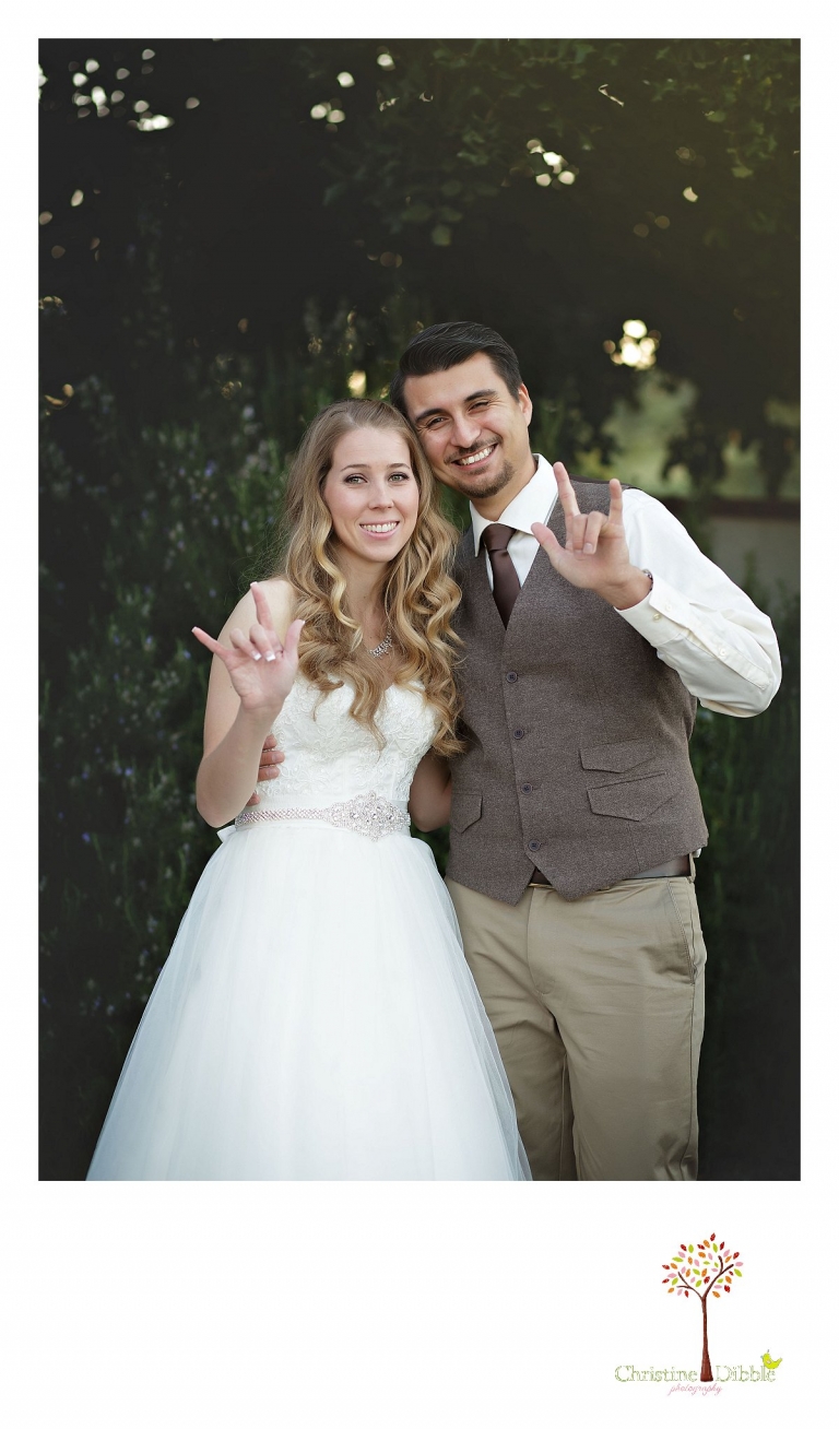 A bride and groom use the American Sign Language sign for "I love you" as they pose for portraits by Don Pedro Hacienda photographer Christine Dibble Photography of Sonora.