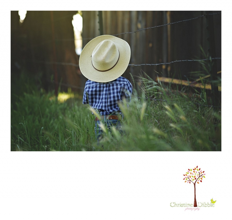 Sonora child photography by Christine Dibble Photography captures a three year old boy in cowboy clothes near a barbed wire fence.