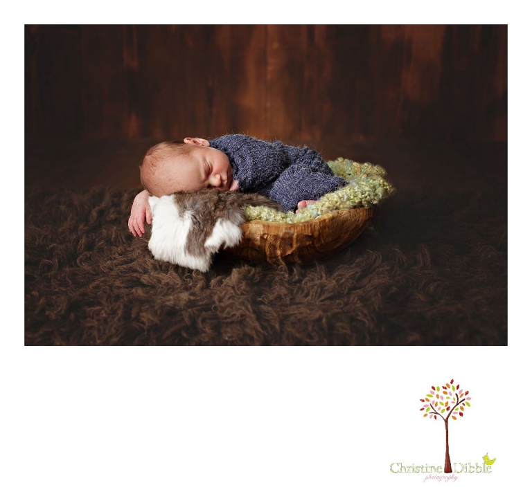 Best Sonora newborn photographer Christine Dibble Photography takes photos of a nine day old baby boy as he sleeps on a rabbit skin in a wooden bowl.